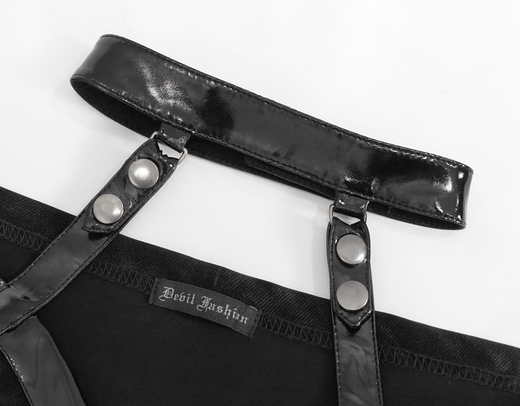 Close-up of glossy black leather straps with snaps, part of an elegant gothic dress design.