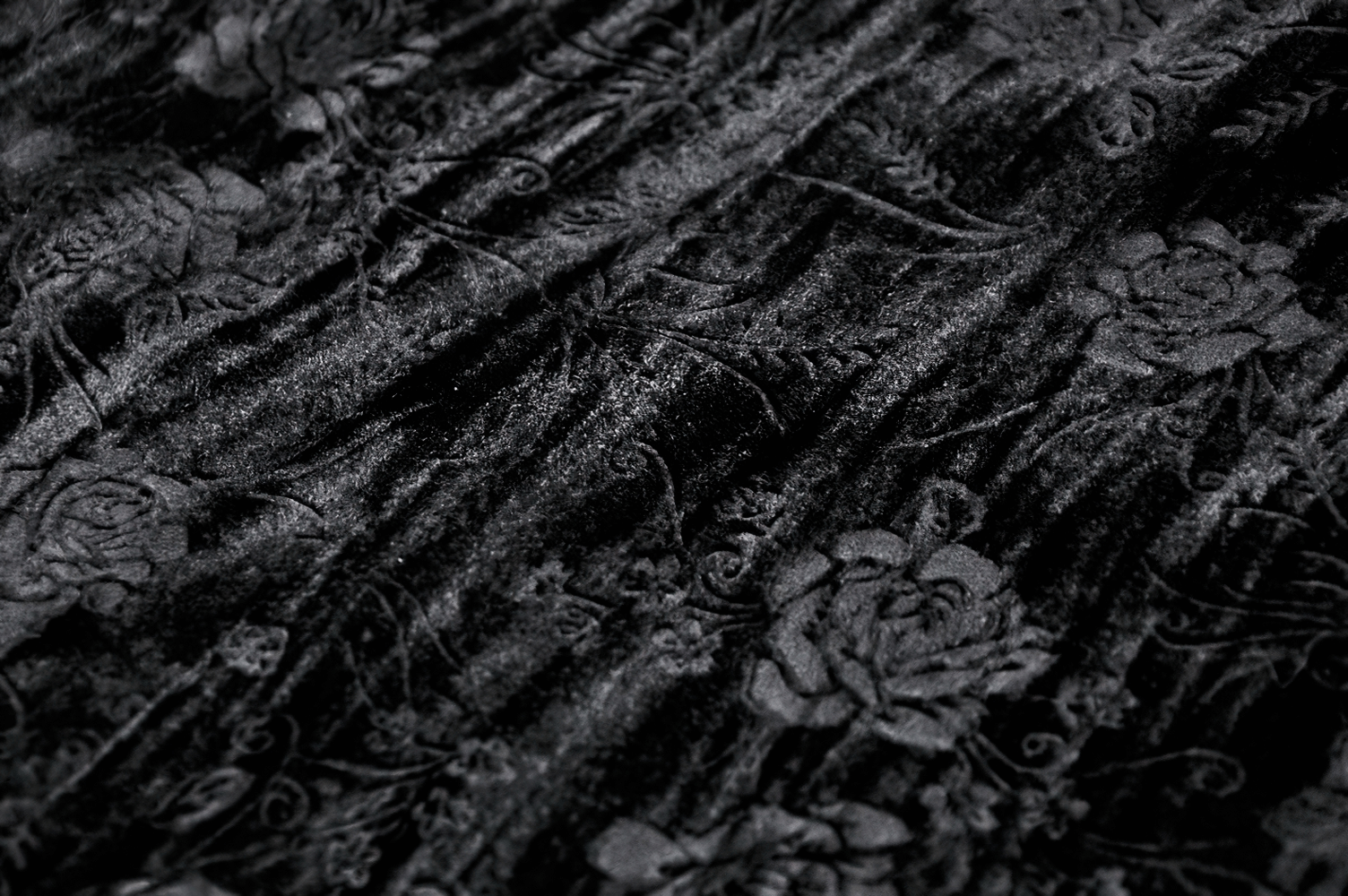 Luxurious black velvet fabric with intricate floral and vine patterns, perfect for elegant gothic attire.
