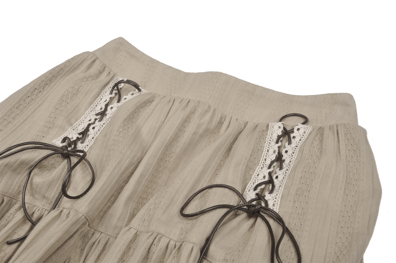 Close-up of an elegant beige layered skirt featuring lace and ribbon details for a chic look.