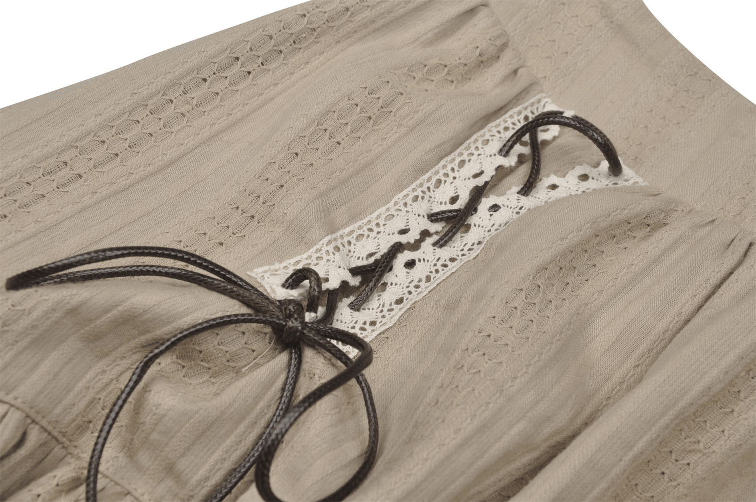 Close-up of beige skirt with lace detail and ribbon tie, showcasing elegant craftsmanship and stylish ruffled design.