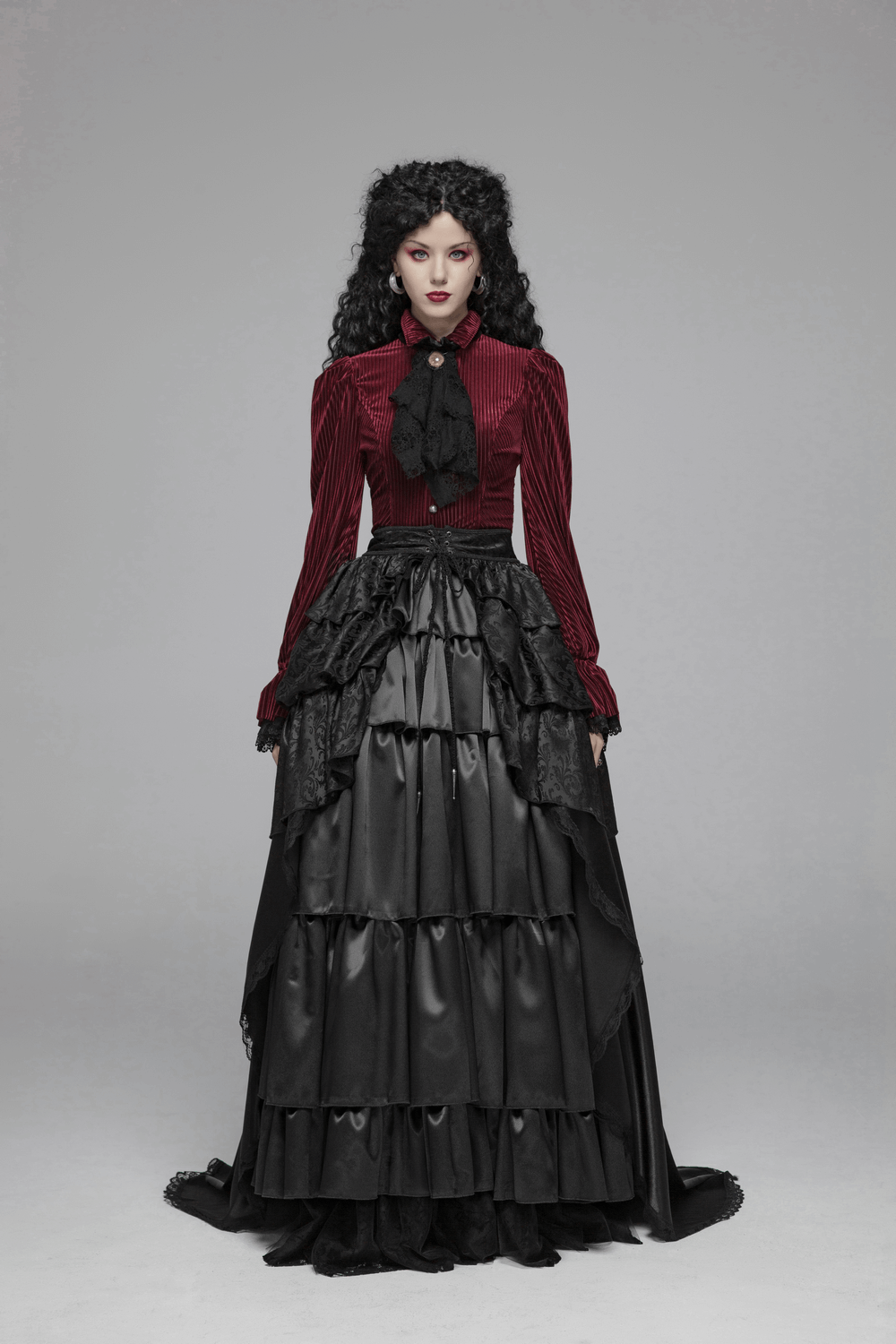 Elegant woman in gothic-style burgundy velvet corset shirt and black layered skirt, exuding Victorian charm.
