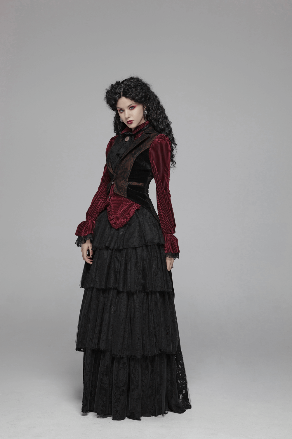 Gothic fashion model in burgundy velvet corset shirt and layered black skirt, showcasing Victorian elegance.