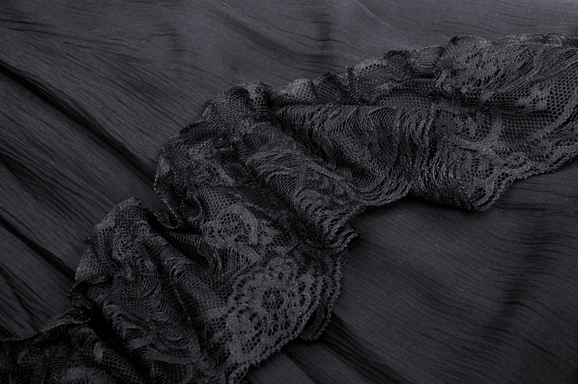 Close-up of black lace ruffle detail on an elegant tiered maxi skirt for a dramatic and romantic look.