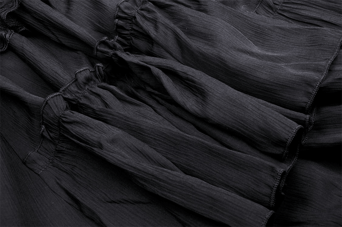 Close-up view of elegant black fabric with ruffles, showcasing soft texture and layered design for a chic style.