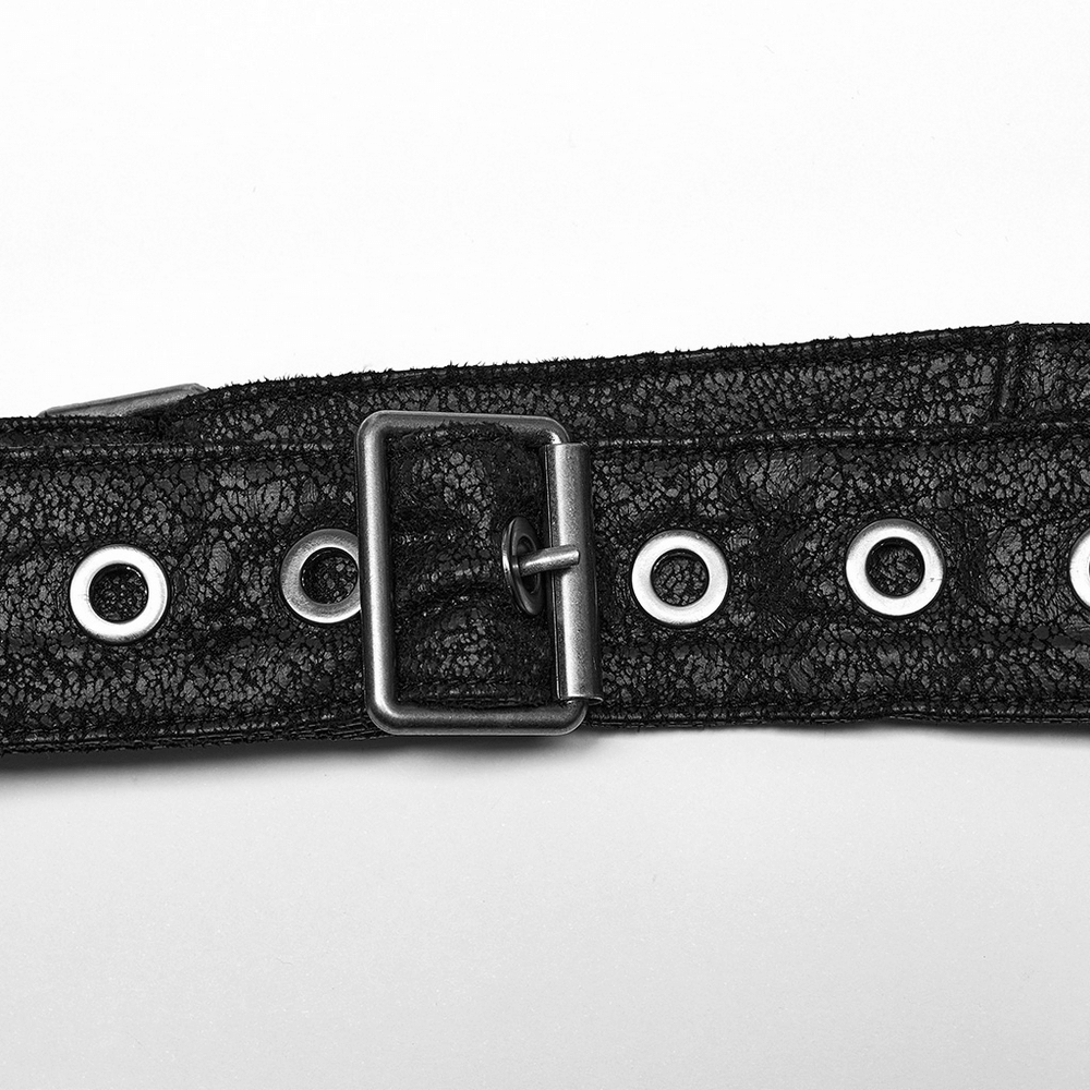 Close-up of embossed black leather belt with adjustable buckle and grommets, perfect for gothic style accessories.