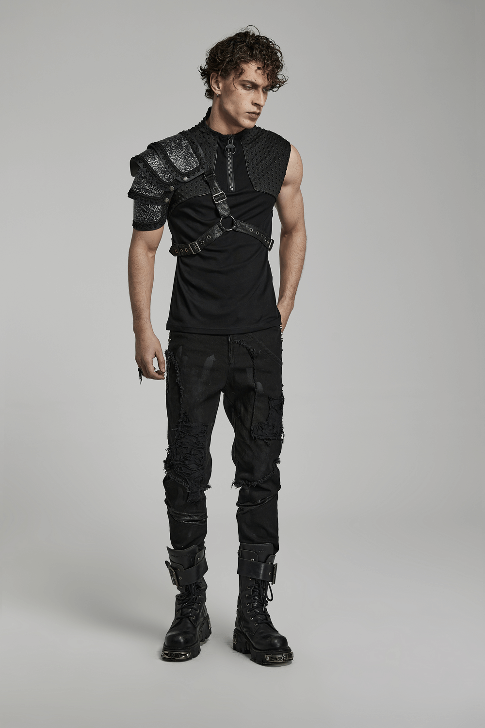Stylish man wearing an embossed leather gothic shoulder guard and rugged black outfit, showcasing edgy fashion.