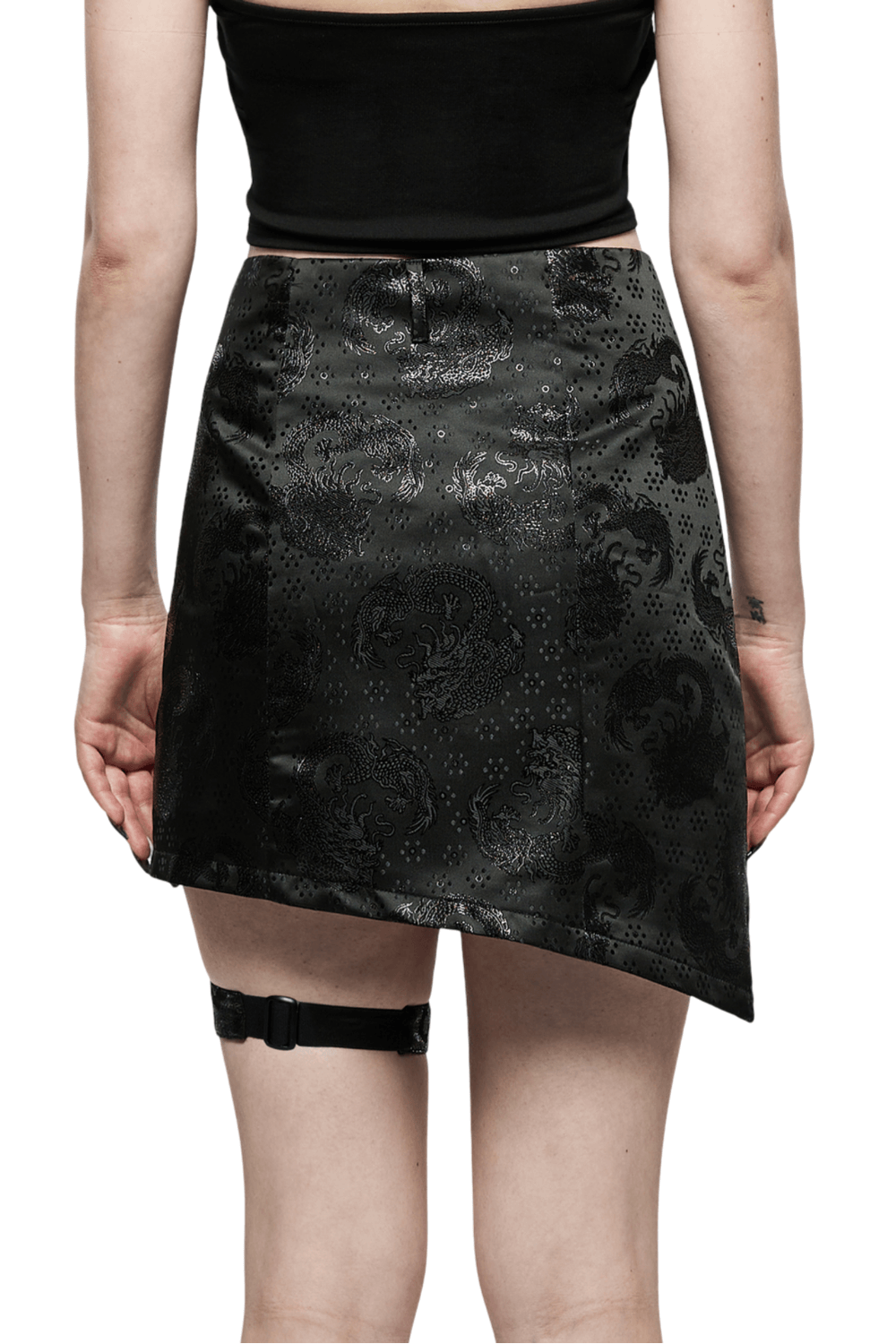 Embroidered dragon asymmetrical skirt with garters, showcasing sleek black jacquard fabric and avant-garde design.