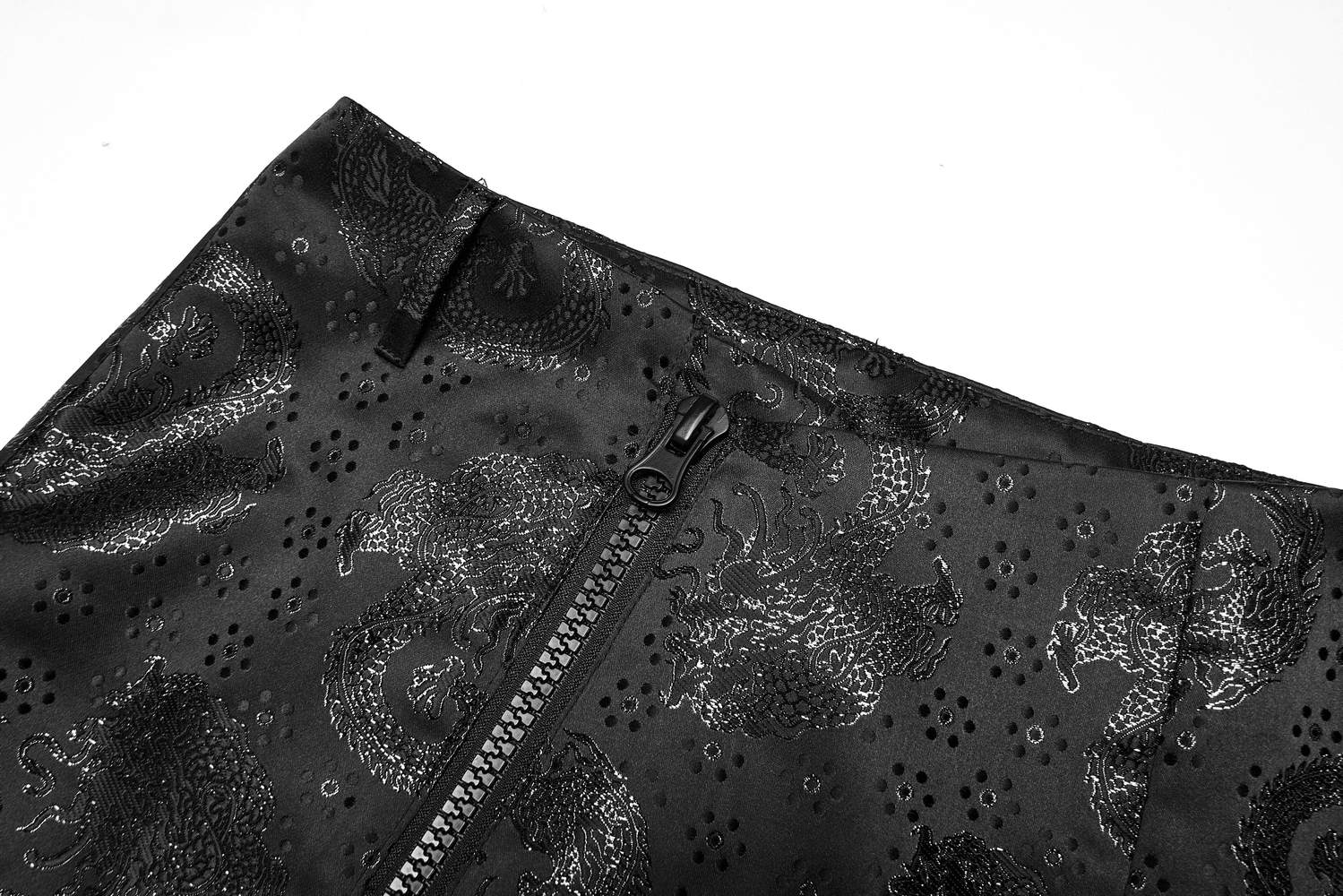 Close-up of embroidered dragon jacquard texture on an asymmetrical skirt, featuring a sleek zipper detail.