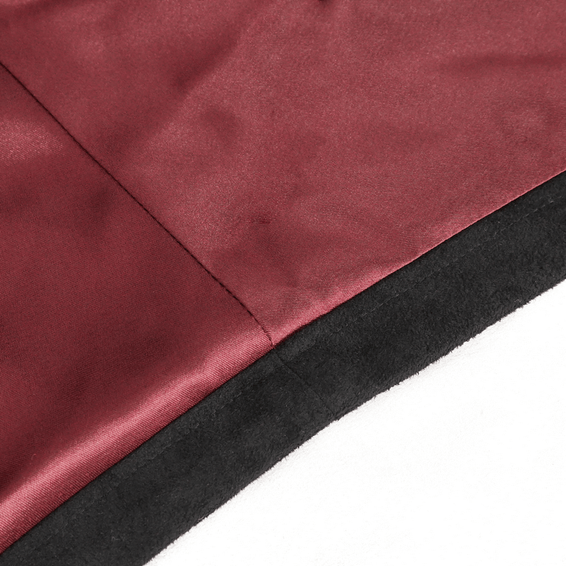 Close-up of burgundy fabric showcasing embroidery and black detailing on a gothic top.