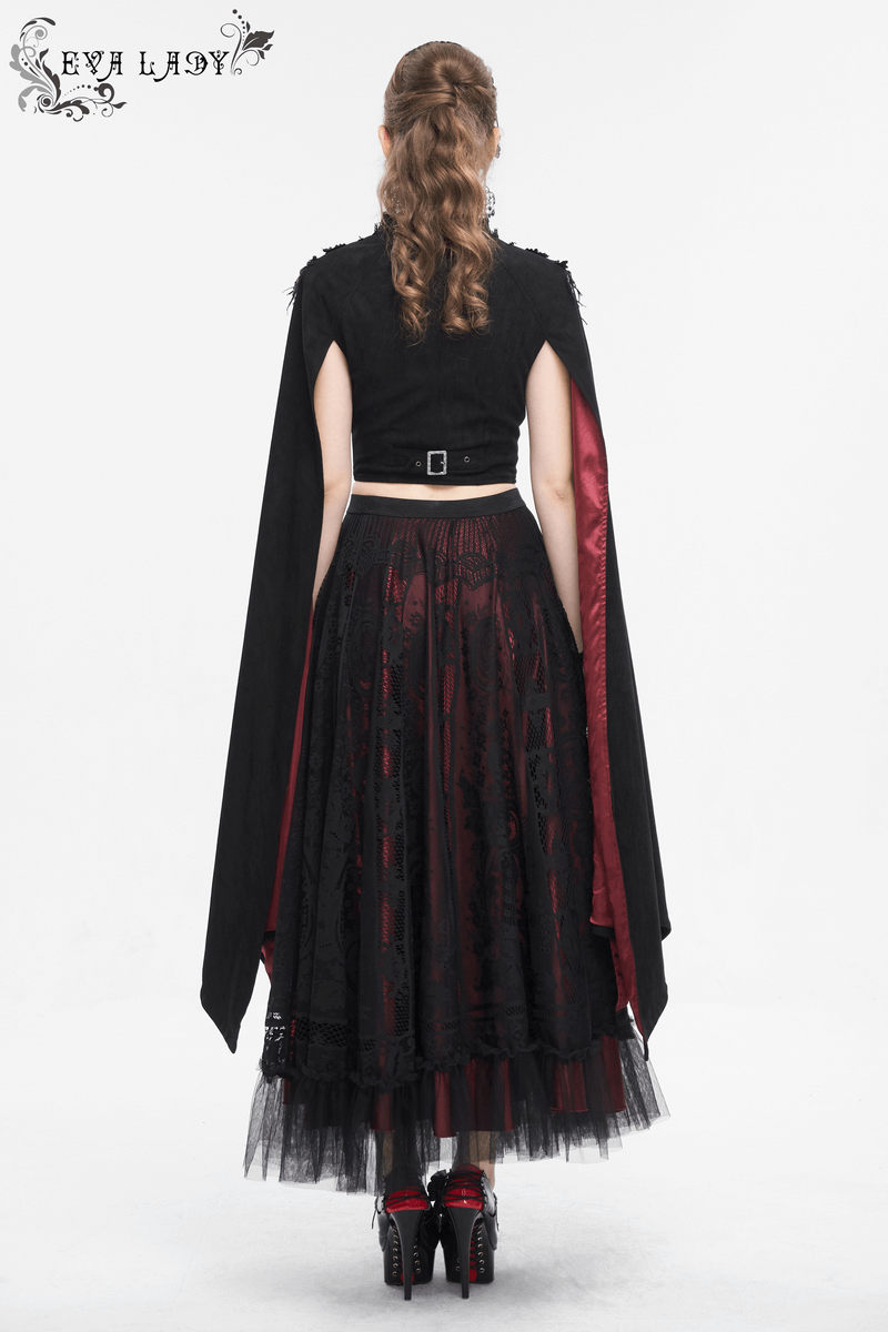 Back view of a woman in a gothic outfit featuring a black top with a cape and a layered red and black skirt.
