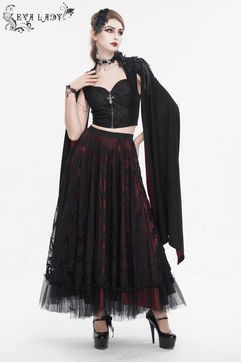 Gothic woman in elegant black top and long skirt, showcasing embroidery details and flared sleeves for a dramatic look.