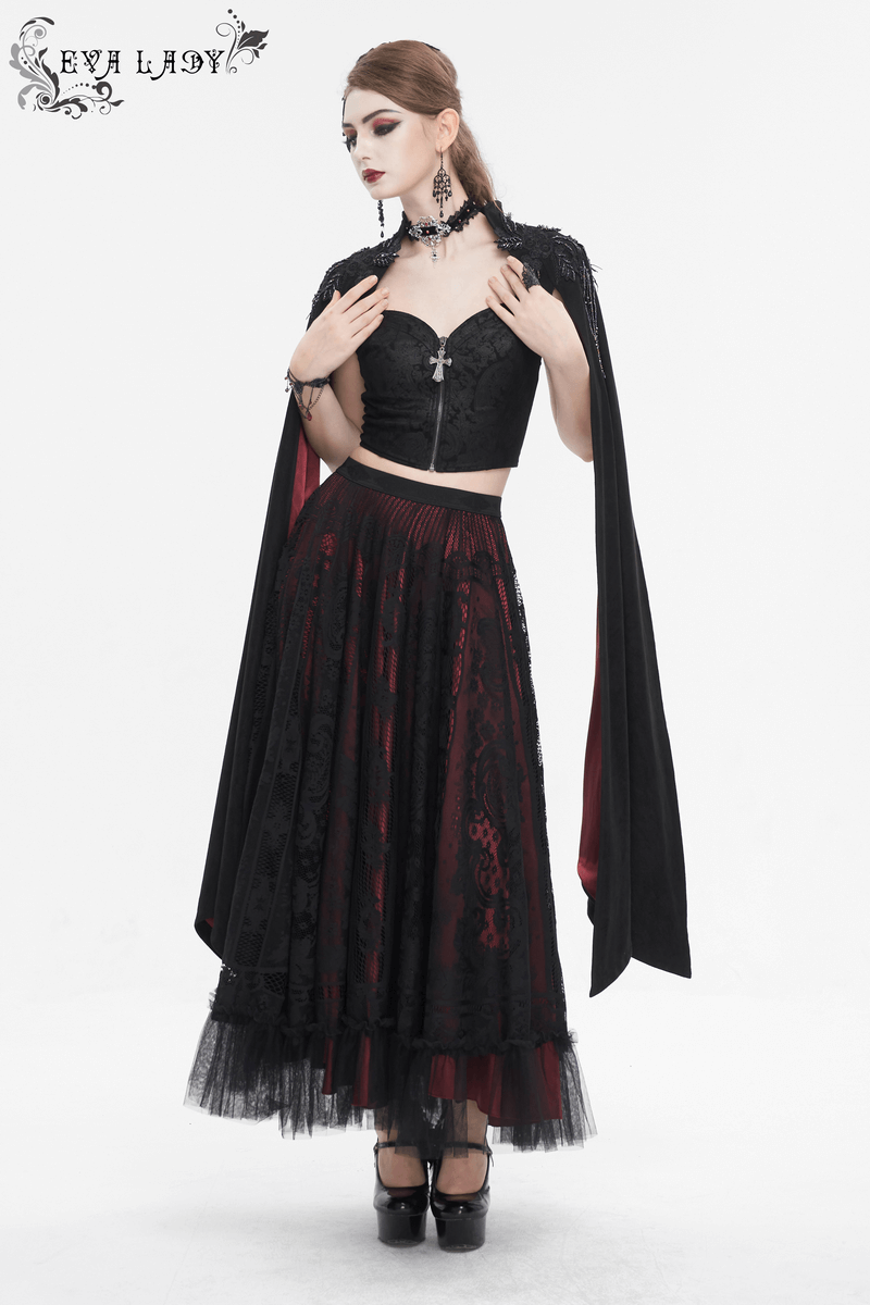 Gothic woman in black crop top and long black skirt with red accents, showcasing alternative fashion style.