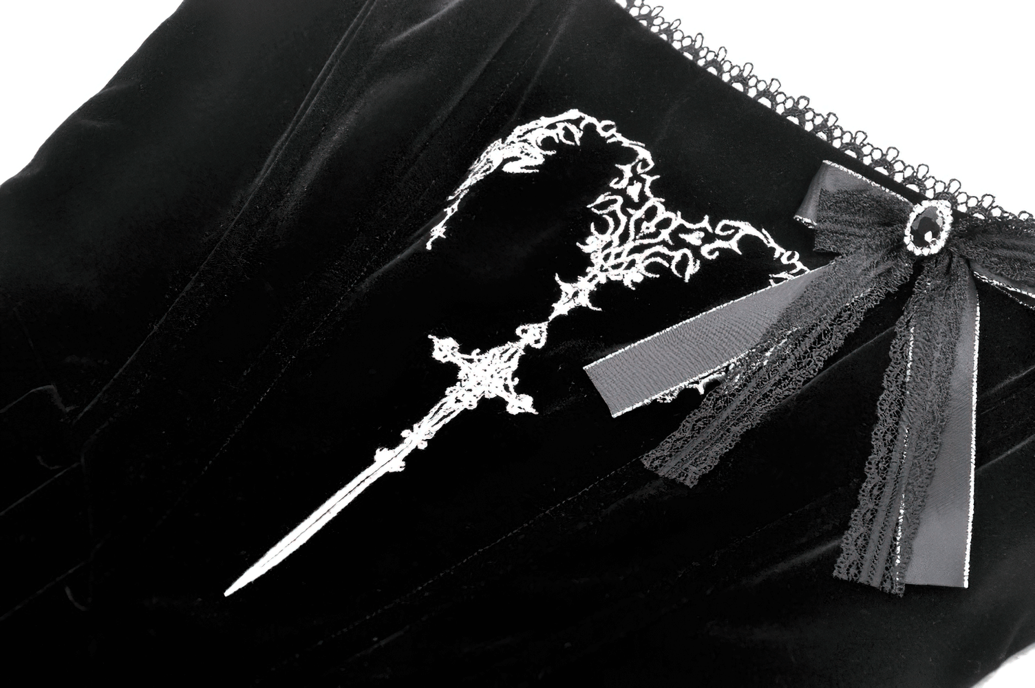 Close-up of lace-up black dress featuring intricate silver embroidery and a stylish bow accent on soft velvet fabric.
