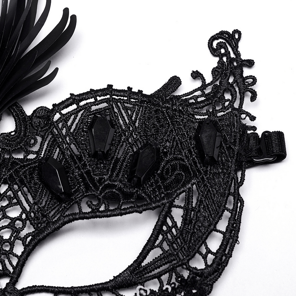 Close-up of a gothic lace eye mask featuring black sequins and coffin-shaped embellishments.