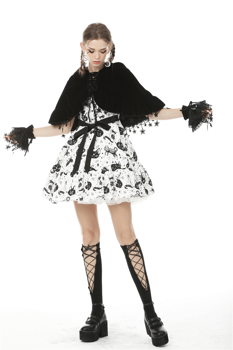 Model wearing a gothic velvet cat ear cape with star tassels over a whimsical black and white dress.