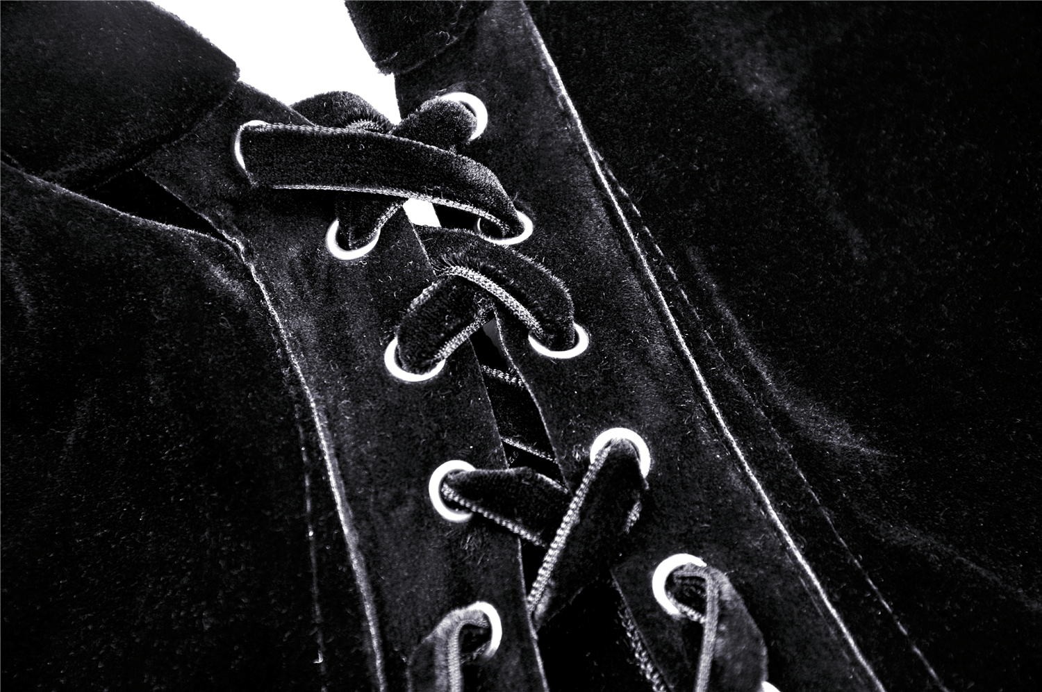 Close-up of the lacing detail on a black velvet cape, showcasing gothic elegance and intricate craftsmanship.