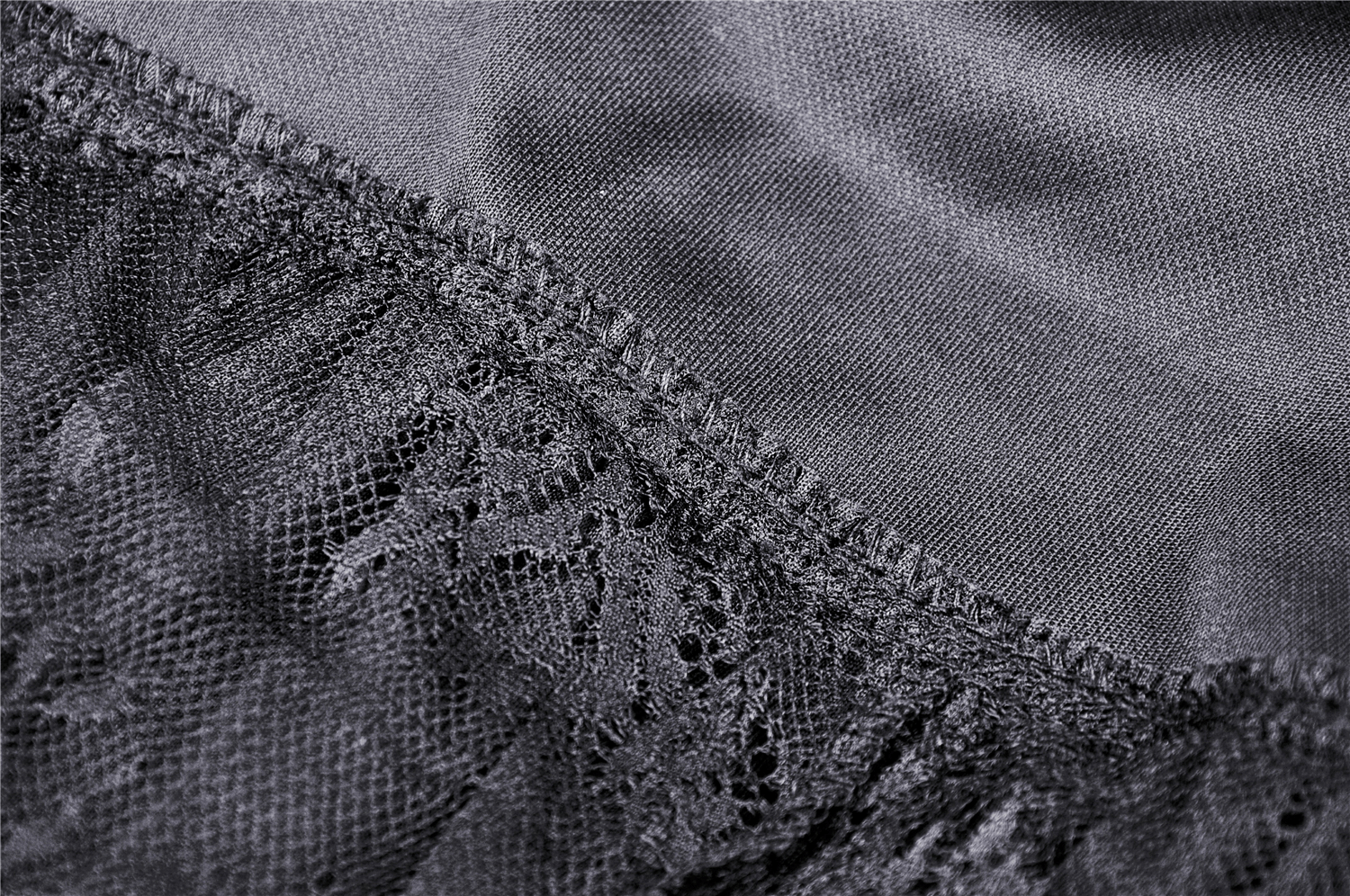 Close-up of elegant black velvet fabric with lace detailing, showcasing a gothic style.