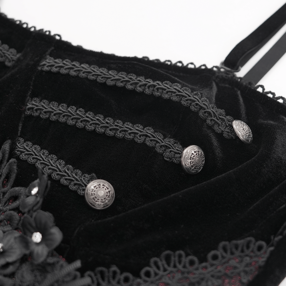 Close-up of dark velvet dress showing intricate beaded lace appliques and silver buttons, perfect for gothic fashion.