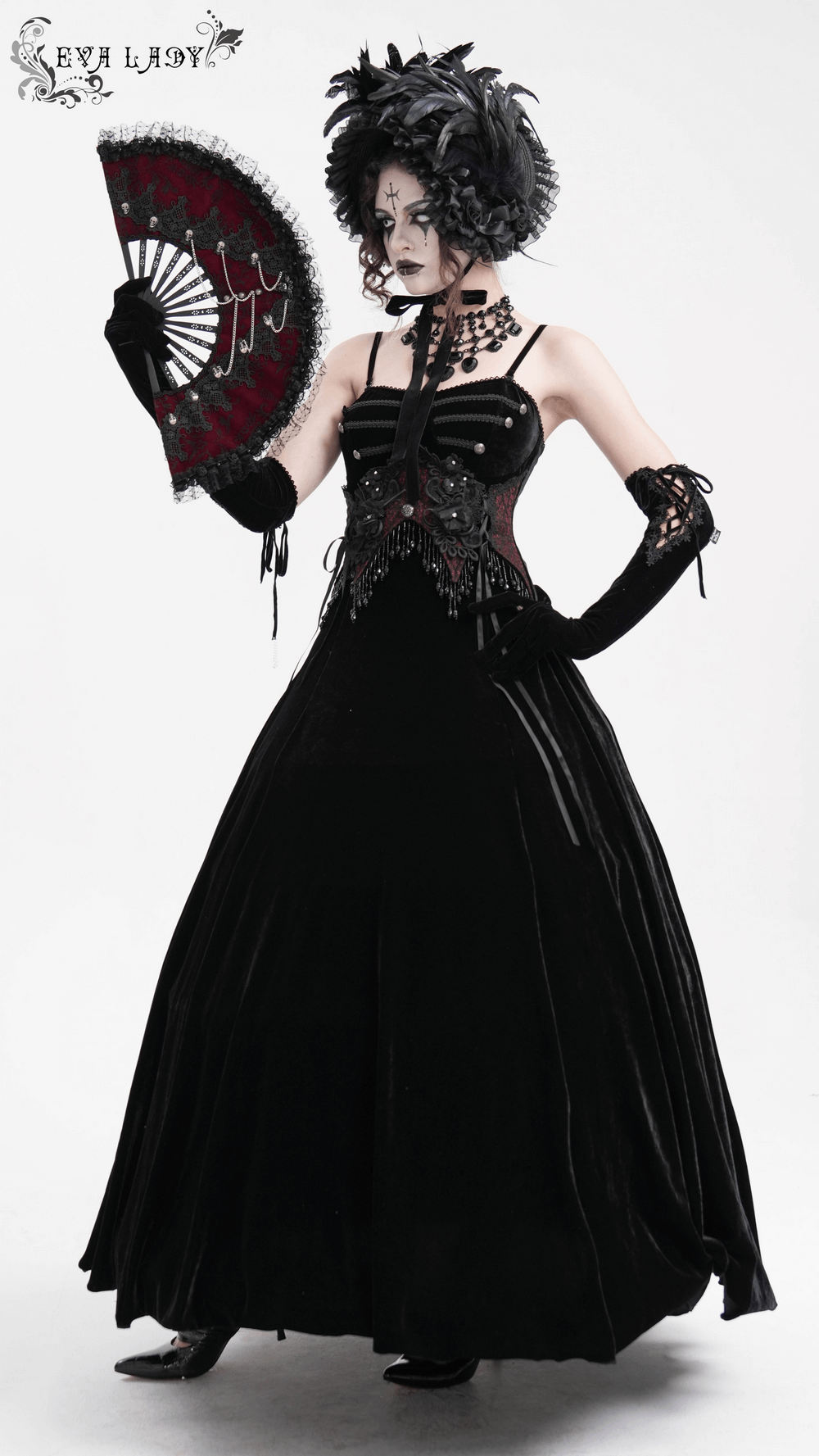 Gothic black velvet maxi dress with beaded lace, elegant fan, and dramatic gloves for alternative fashion styles.