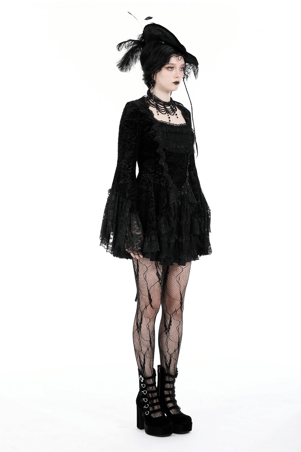 Gothic black lace dress with ruffled sleeves, fishnet stockings, and stylish platform boots for a dark, elegant look.