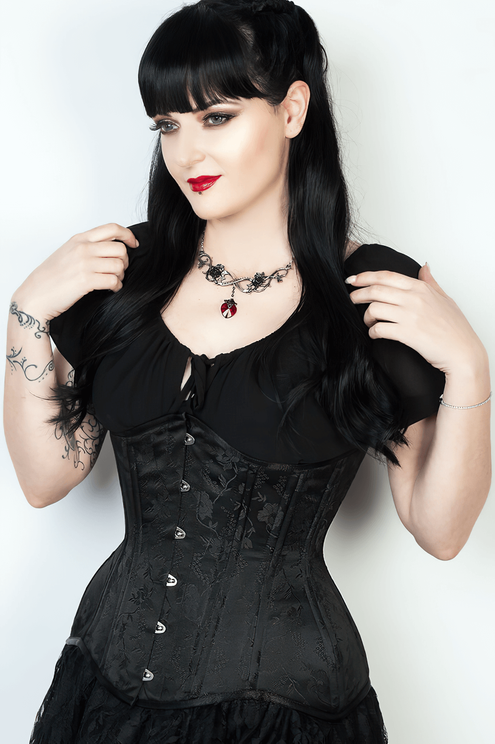 Gothic model wearing an exquisite black underbust corset with floral brocade, showcasing waist shaping and vintage style.