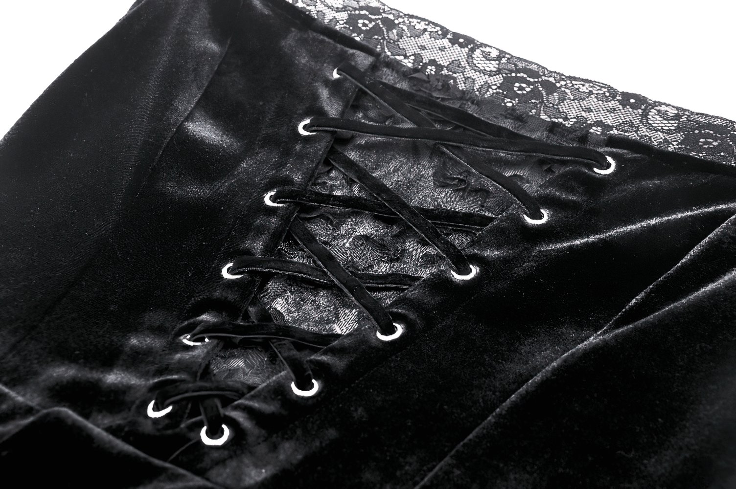 Detailed view of lace-up black velvet dress showcasing elegant lace overlay and ruffle accents.