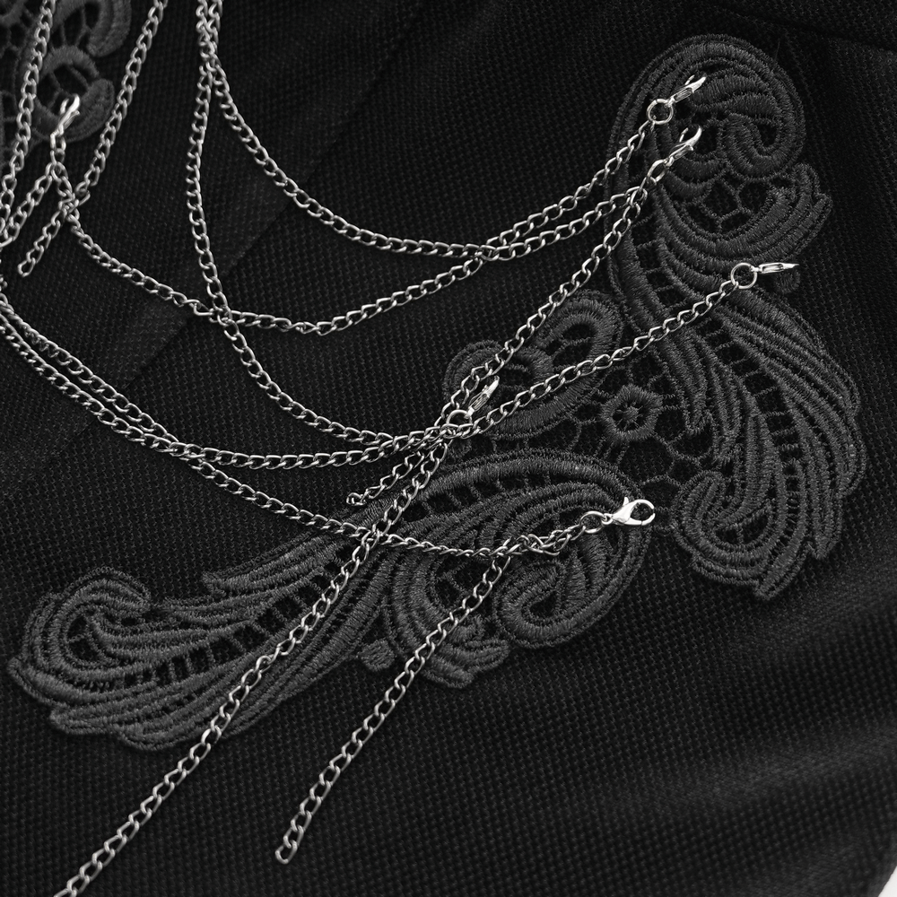 Elegant lace detailing with silver chains on black fabric, showcasing gothic style and modern fashion aesthetics.