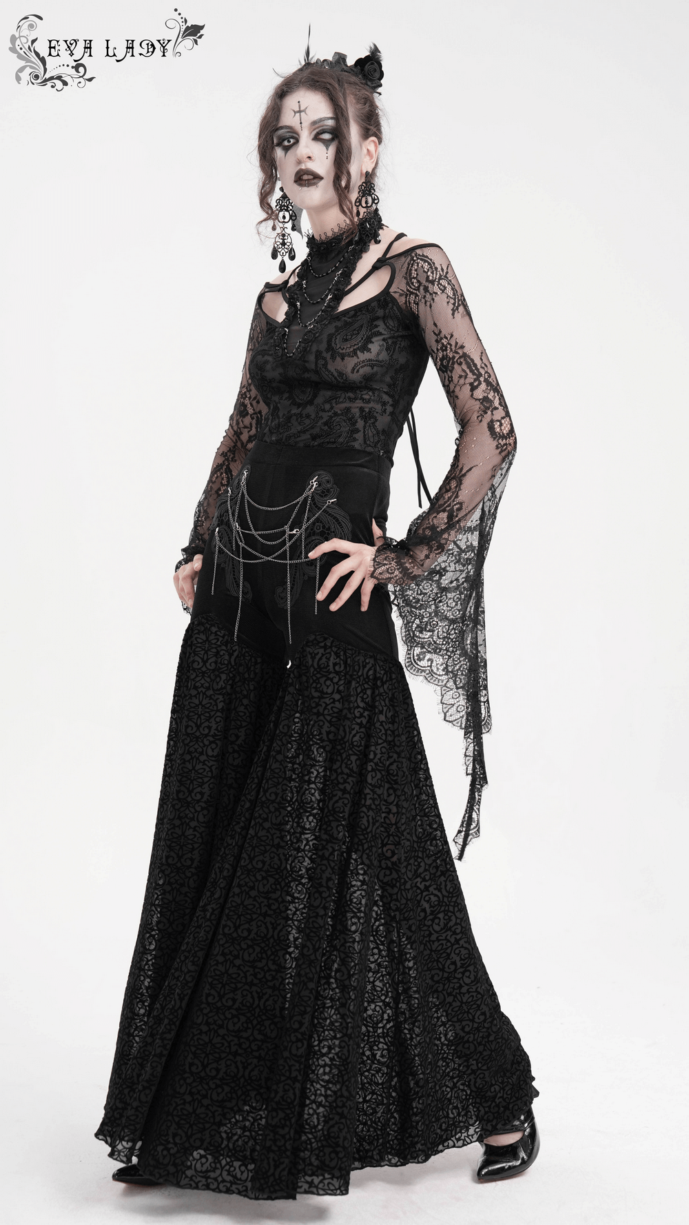 Elegant woman in gothic lace palazzo pants with chain details, showcasing alternative fashion and romantic style.