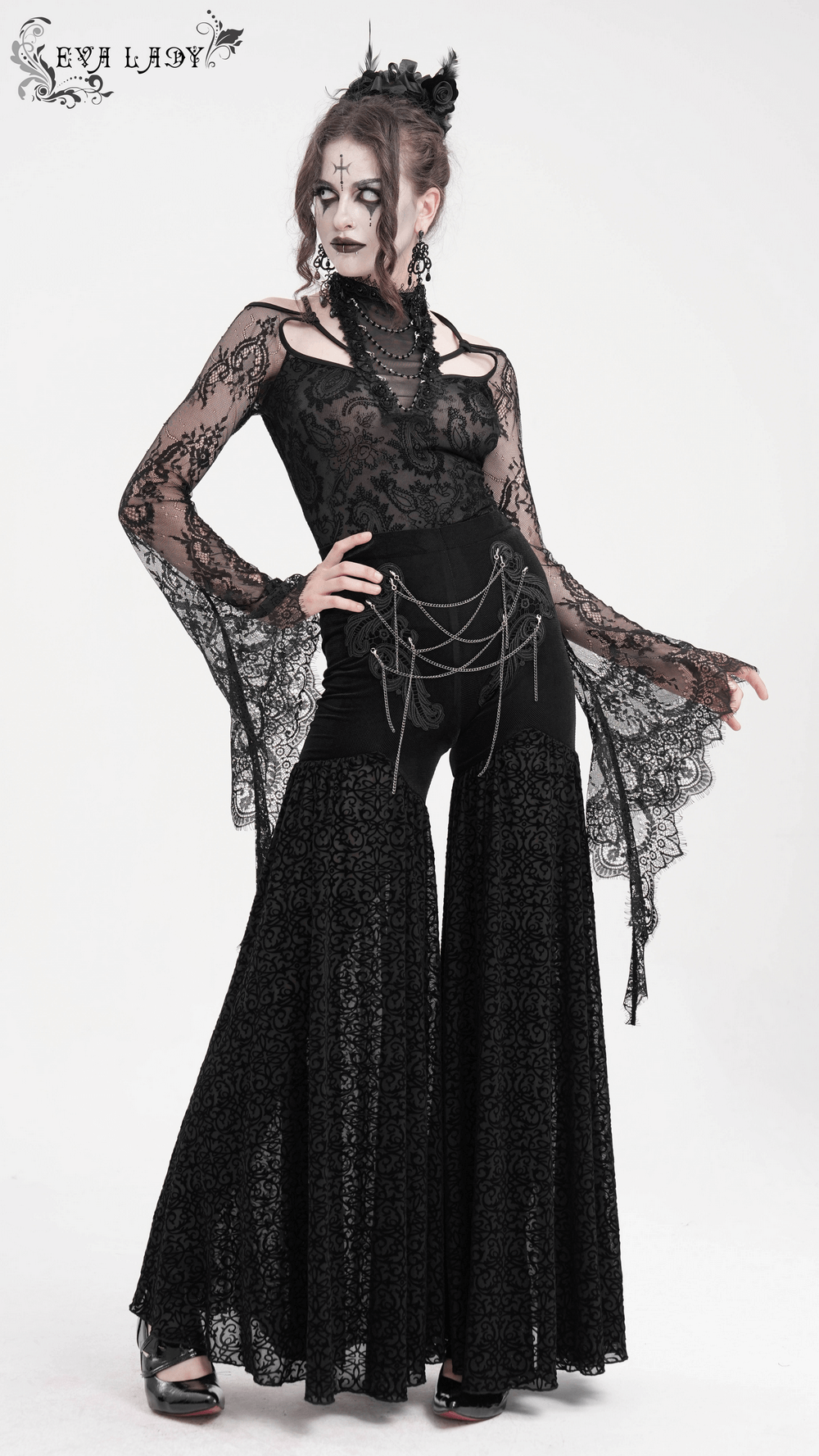 Elegant woman in gothic lace palazzo pants with chain detailing, showcasing a bold and romantic fashion statement.