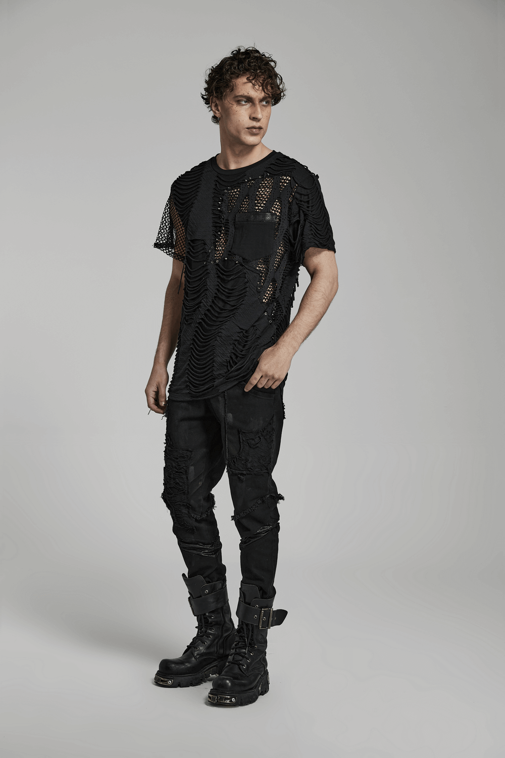 Edgy eyelet-studded punk t-shirt with mesh splice design worn by model, showcasing bold style and unconventional fashion.
