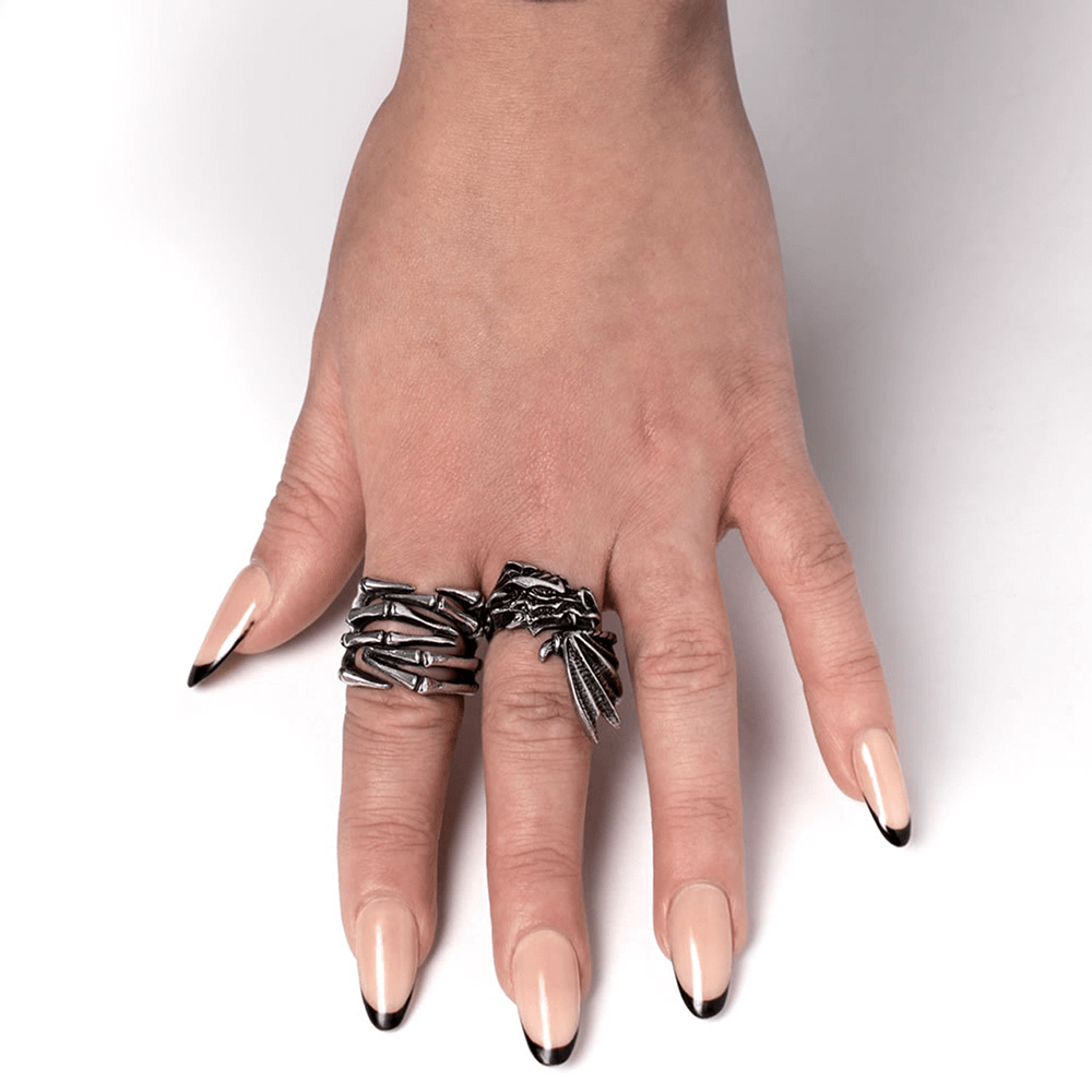 Hand modeling two intricate fantasy dragon rings in antique pewter with elegant long nails.