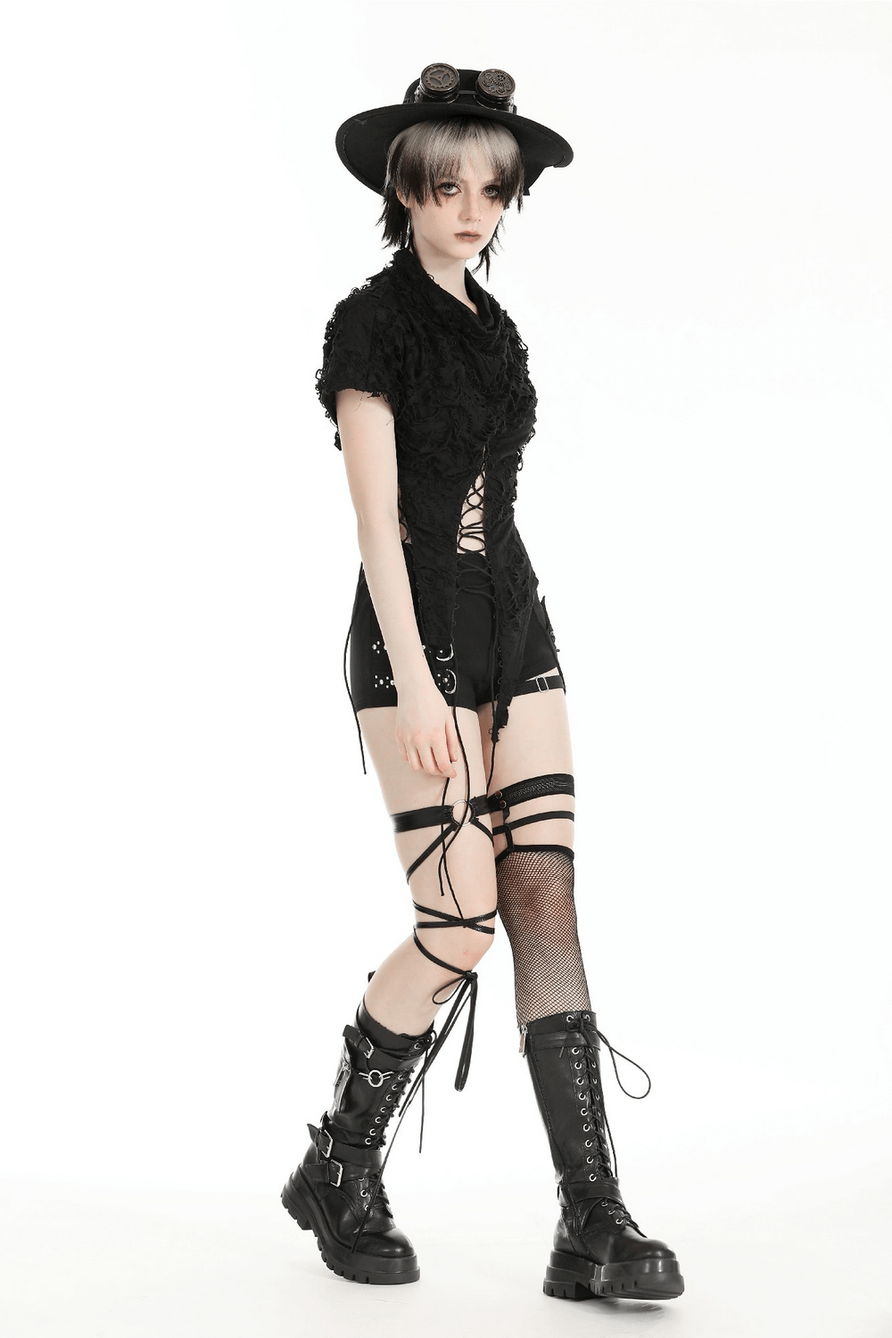 Edgy black asymmetrical ripped lace-up top paired with shorts and stylish chunky boots, perfect for gothic fashion.