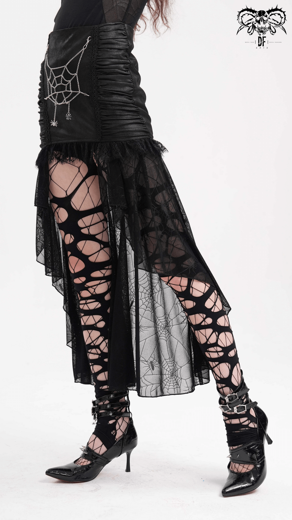 Black asymmetric spider web gothic skirt with lace detailing, paired with stylish spider web leggings and heels.