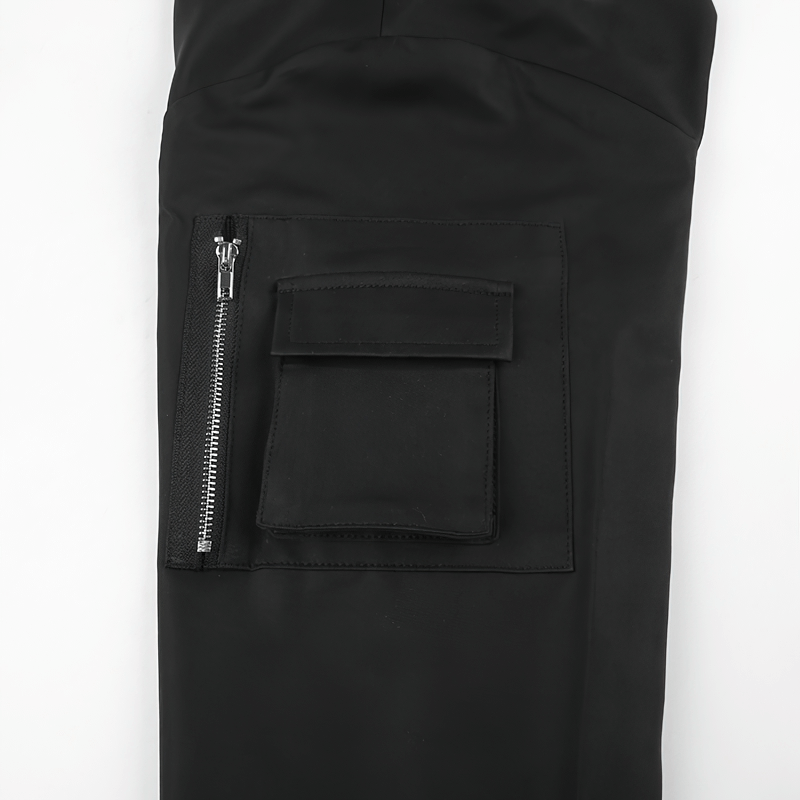 Close-up of a black cropped top sleeve featuring a zipper and a pocket, showcasing punk fashion details.