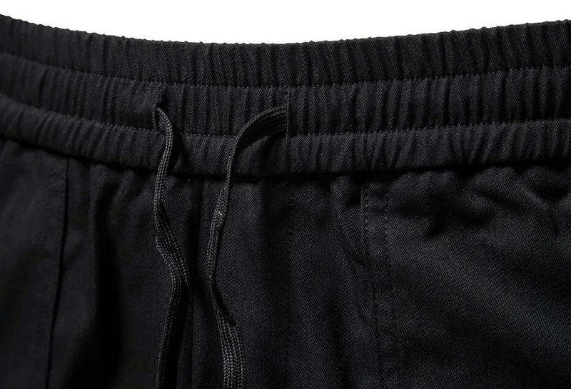 Close-up of men's fashion cargo pants waistband with elastic and drawstring for comfort and style.