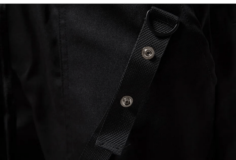 Close-up detail of black fashion cargo pants showing adjustable strap and snap button features.