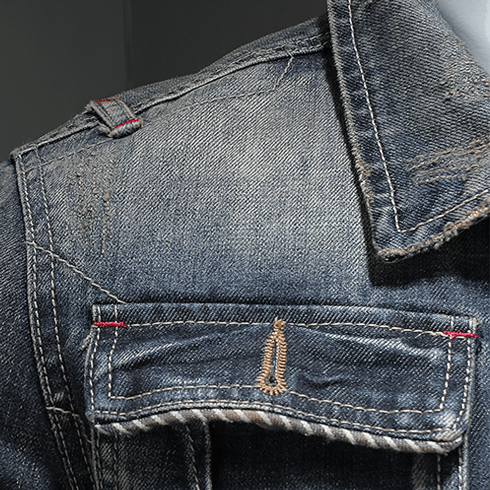 Close-up of a stylish gray denim jacket for men, showcasing the distressed fabric and detailed stitching.