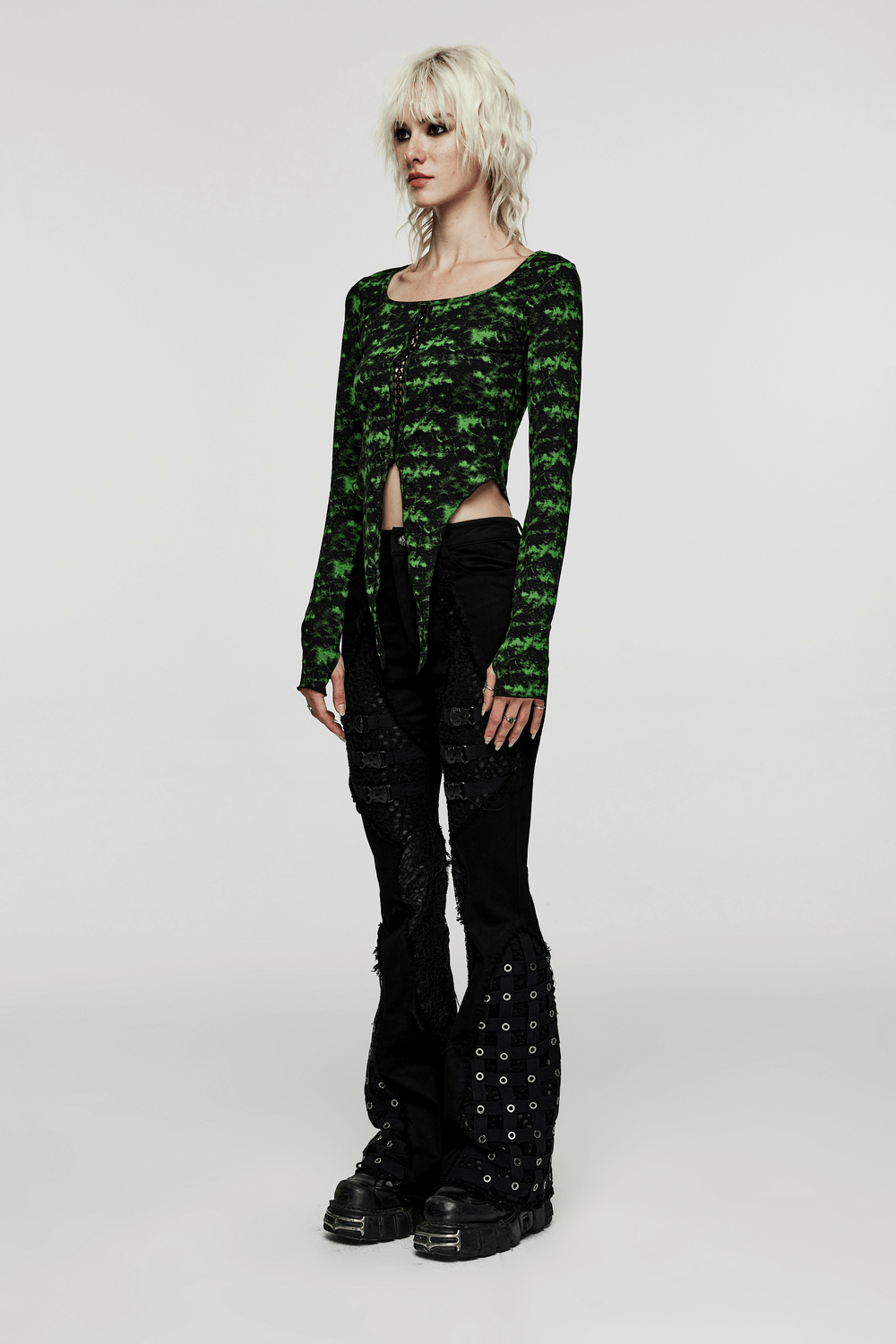 Model wearing a green edgy punk long sleeve irregular hem knit top, styled with black punk pants and chunky boots.
