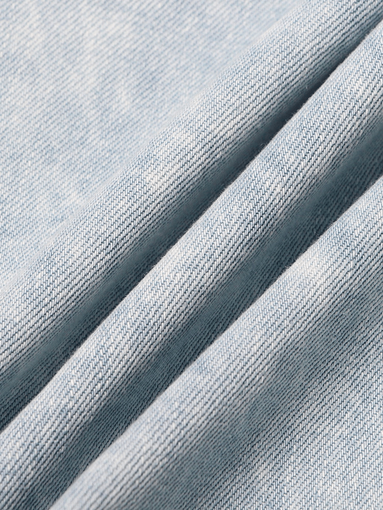 Light blue denim fabric close-up showcasing the texture and weave for fashion pants.