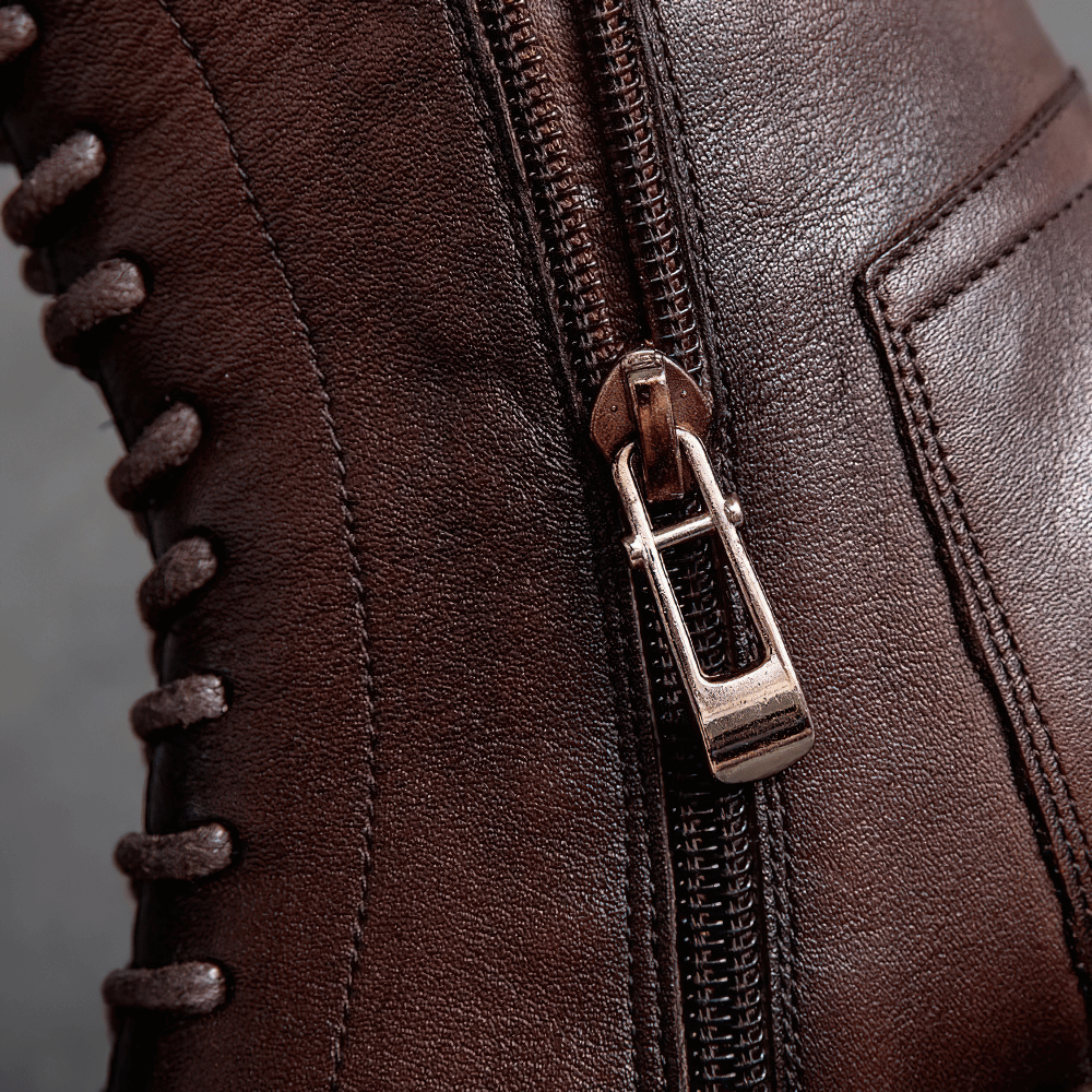 Close-up of a stylish brown ladies ankle boot showing zipper and lace details for a modern casual look.