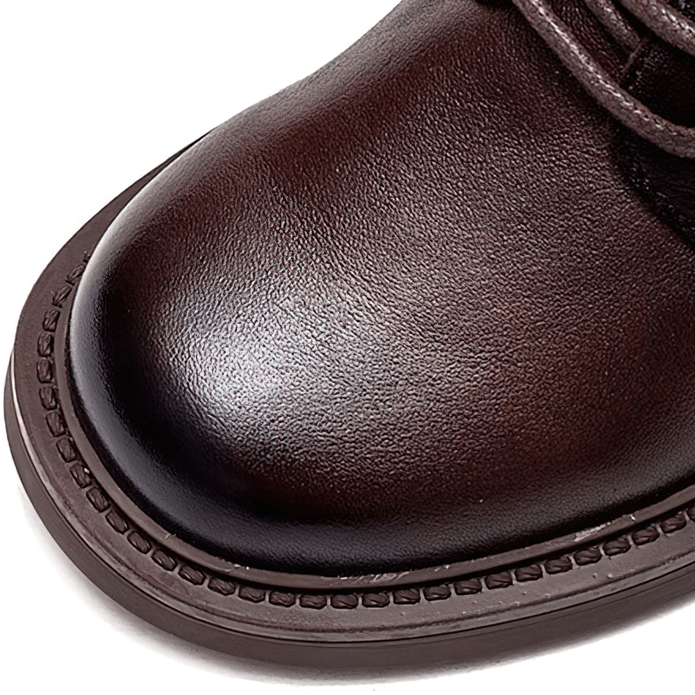 Close-up of a stylish brown genuine leather ankle boot featuring a sleek design and lace-up detail.