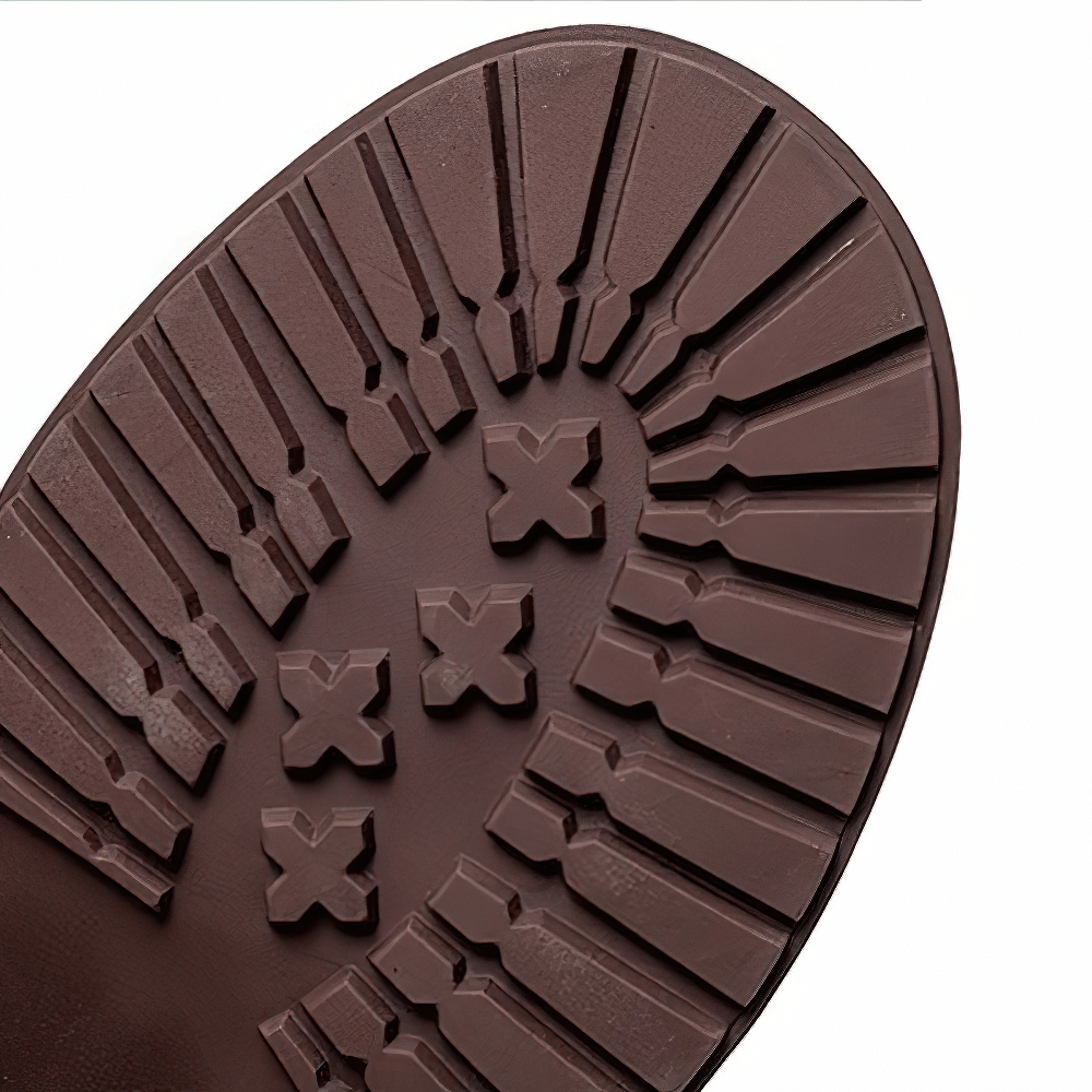 Close-up of the rubber sole of stylish ladies leather boots with unique tread pattern.