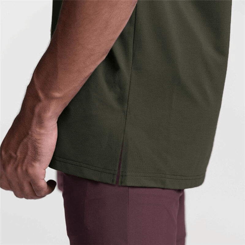 Close-up of a man's arm holding the side of a green sleeveless tank top, showcasing its sporty design and comfortable fit.