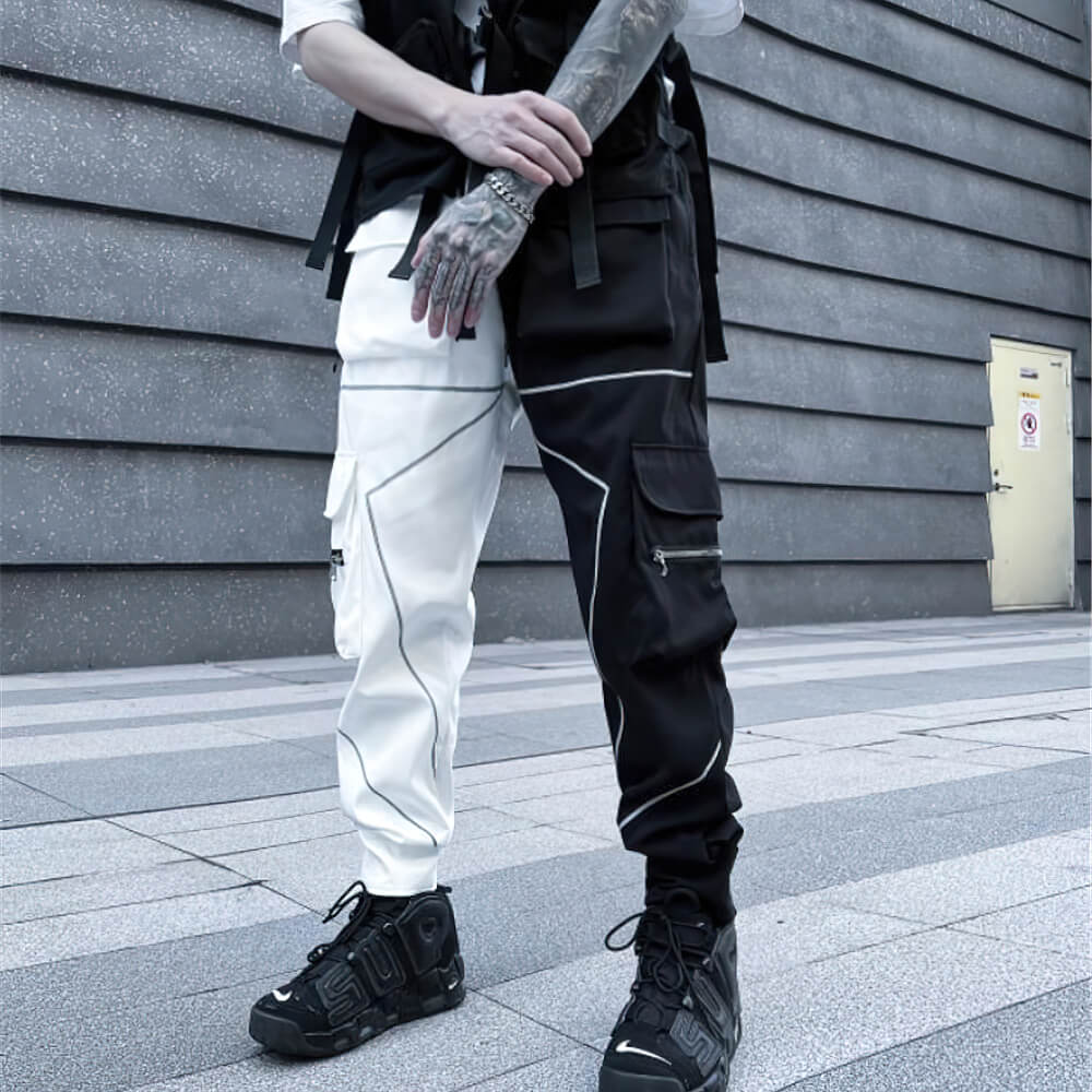 Men's patchwork cargo trousers, black and white, with pockets and elastic waist, styled with edgy sneakers.