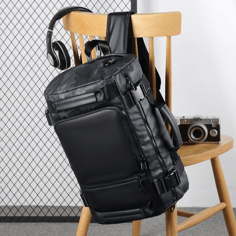 Stylish multifunctional waterproof backpack hanging on a chair, perfect for outdoor travel and casual outings.