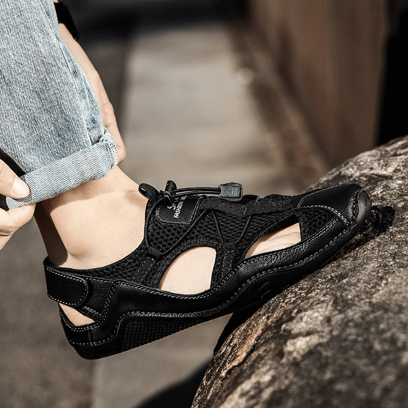 Close-up of a man wearing breathable black leather sandals, showcasing comfort and style in outdoor fashion.