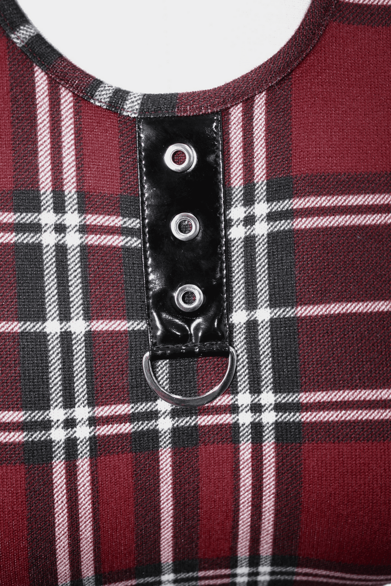 Close-up of a stylish red plaid dress featuring black detailing and decorative silver rings, perfect for punk fashion.