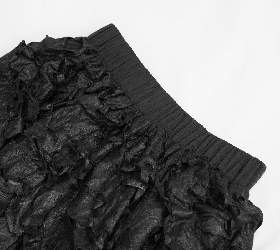 Close-up of a black gothic style skirt with asymmetric hem and elastic waistband, showcasing ruffled texture.