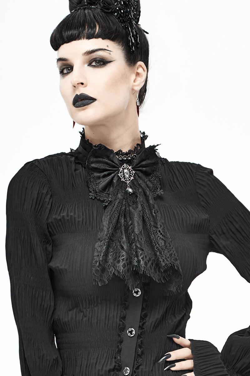 Elegant woman in black gothic attire wearing a lace bow tie accessory with silver brooch.