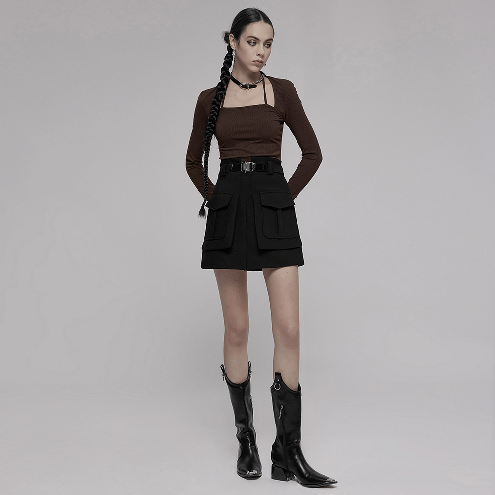 Fashionable model in a high-waist black A-line skirt with buckle and chic pockets, styled with boots and a brown top.
